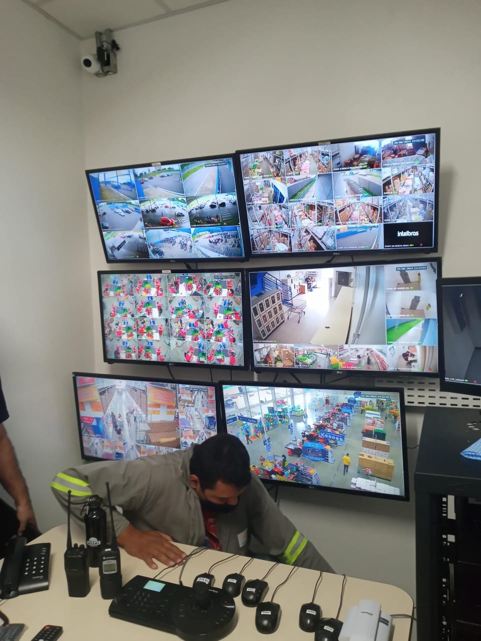 Central de monitoramento CFTV com múltiplos monitores Intelbras — instalação UP Tech