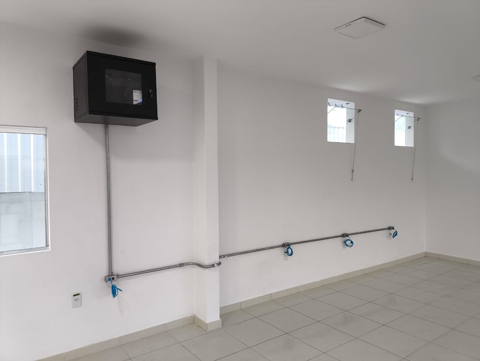 Mini-rack e eletrodutos de rede instalados em sala comercial