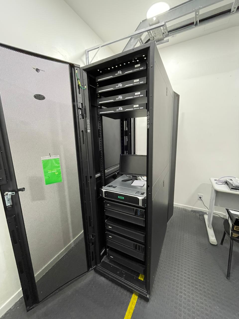 Sala de servidores completa com rack APC, HPE ProLiant, UPS e leito de cabos